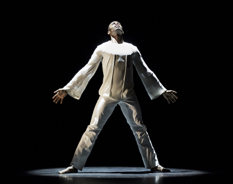 Dancer Jamar Roberts stands under a spotlight with arms outstretched at his side and feet planted firmly on the ground